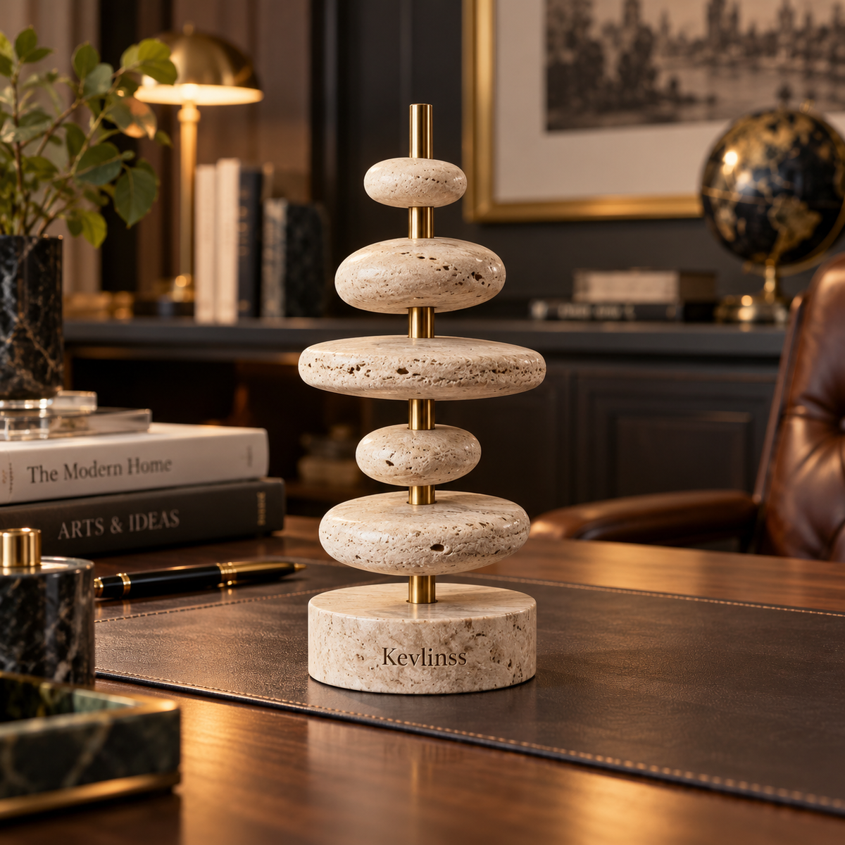 Stacked cream pebble forms on a gold-tone vertical stem and round base